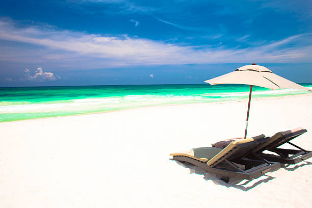 istock two beach chairs and umbrella on sand beach. waves 509736616