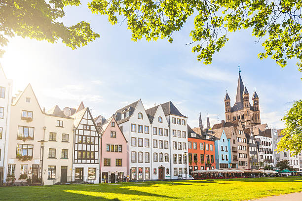 Houses and park in Cologne, Germany Houses and park in Cologne, Germany. Many of them are colourful, they are facing a public park with green grass and some trees. There is a bell tower on background. Travel and architecture concepts. cologne photos stock pictures, royalty-free photos & images