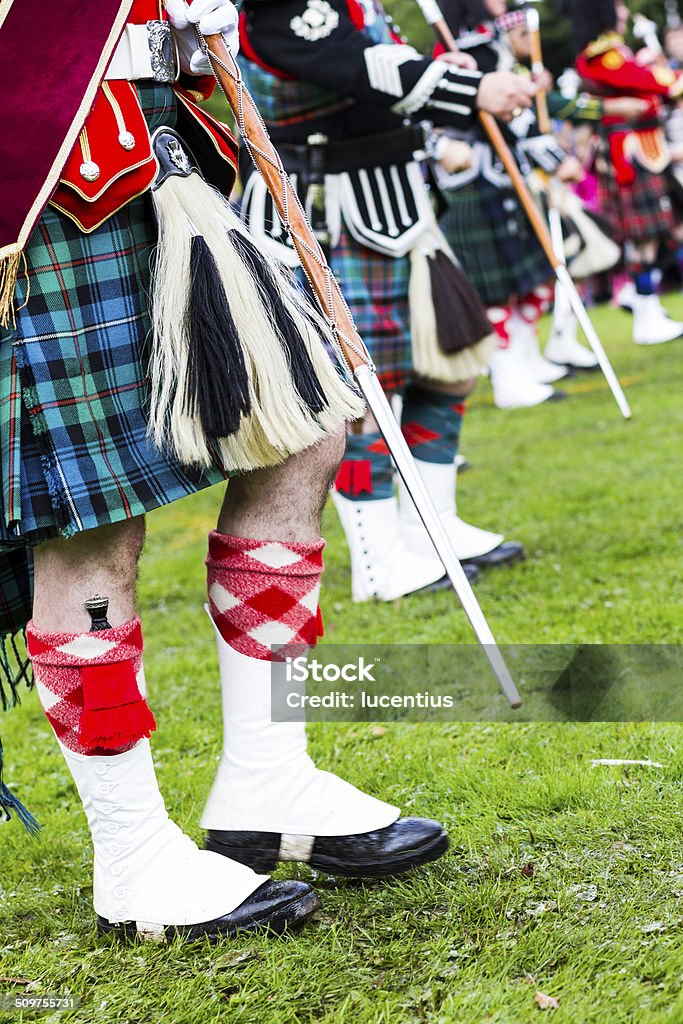 Scottish pipe band Close-up lower body image of marching Scottish pipers with copy space. The foreground figure is the pipe major carrying a mace with maroon sash over the right shoulder and dirk tucked down his stockings and gaiter. AdobeRGB colorspace. Bagpipe Stock Photo