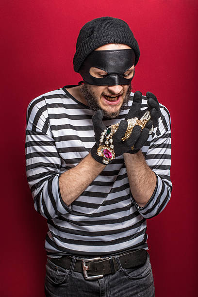 istock Happy thief holding stolen necklace 509758651