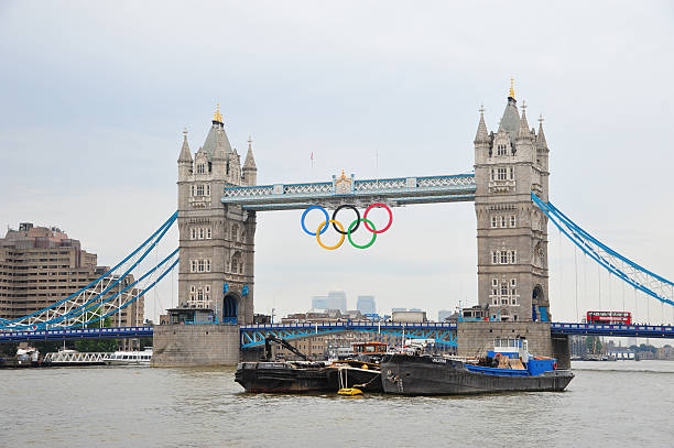 London - Tower Bridge during Olympics London, UK - August 15, 2012: London - View of Tower Bridge with the giant Olympic Rings suspended to mark the 2012 Summer Olympic games in London. Tour bus drives on London Bridge and boats cruise on river Thames. 2012 stock pictures, royalty-free photos & images