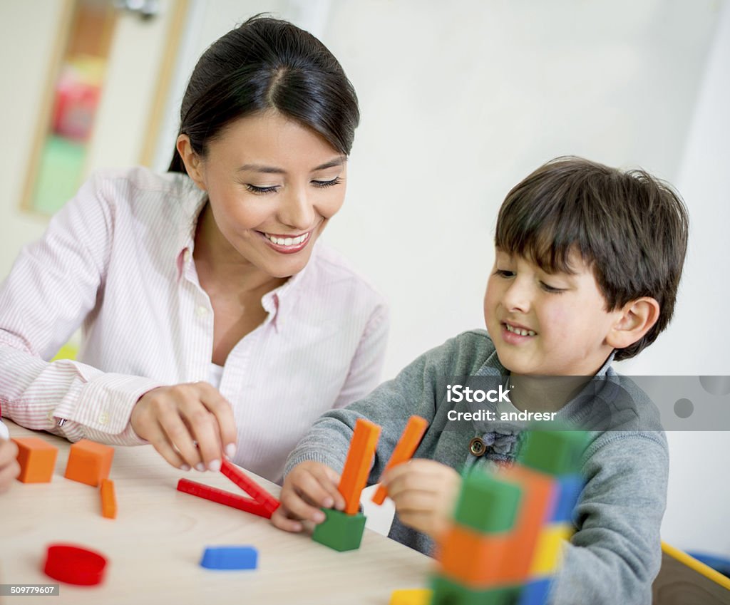 Teacher with a student Teacher with a student in class at the school 4-5 Years Stock Photo