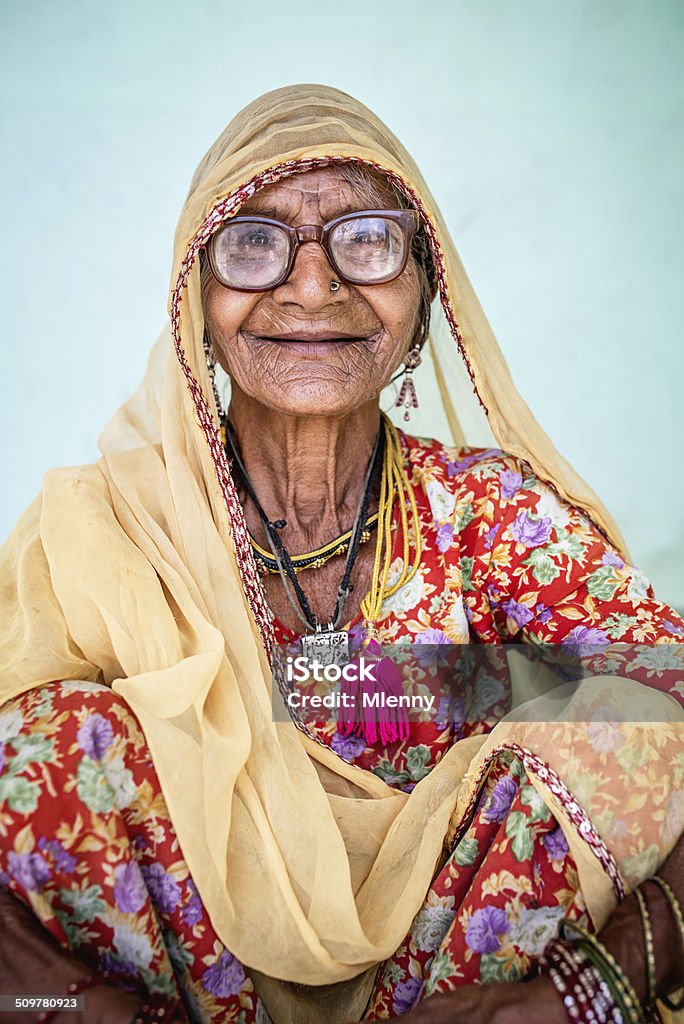 Smiling Senior Indian Woman, Real People Portrait Smiling indian woman in colorful traditional clothes sitting. Real People Portrait. Rajasthan, India. India Stock Photo