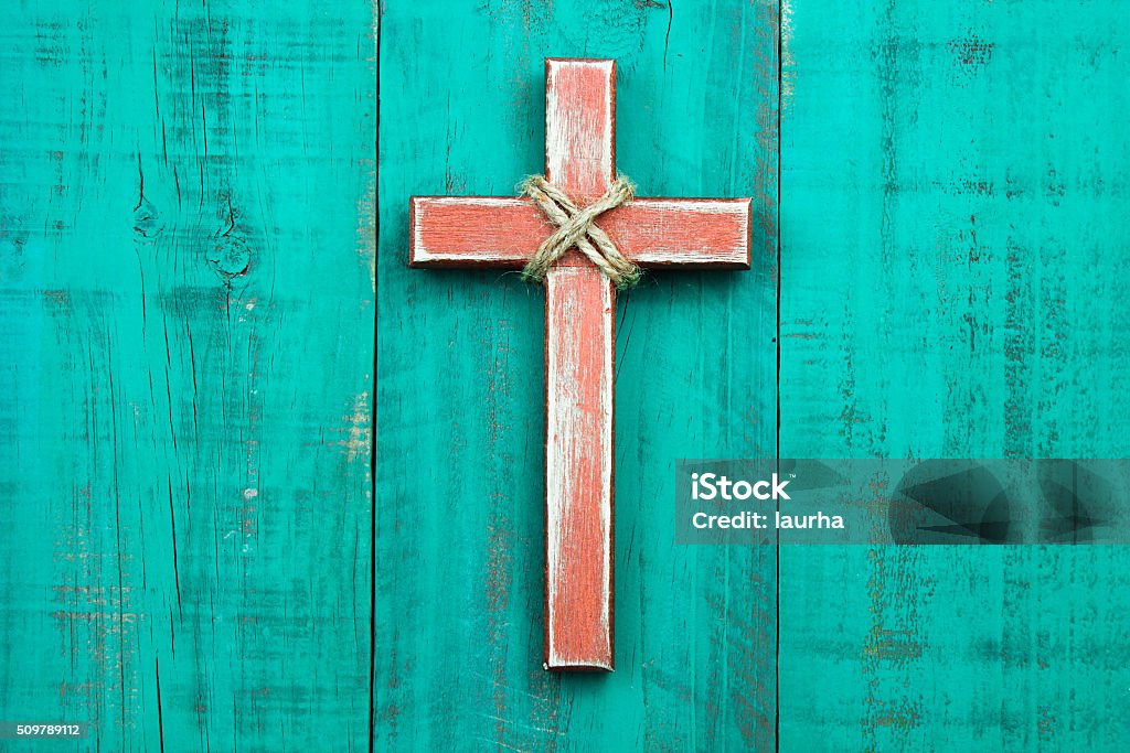 Wood cross hanging on rustic door Rustic wood cross with rope hanging on antique green wooden background Religious Cross Stock Photo