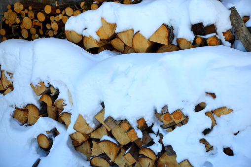 snow covered stack of firewood.
