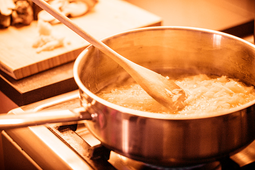 Closeup image of cooking pan with wooden spatula.