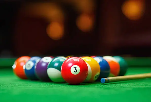 Photo of Billiard balls in a green pool table