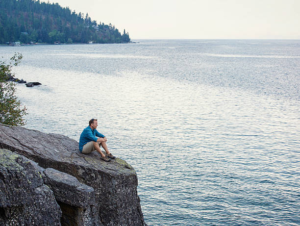 istock Man meditating and praying on cliff edge overlooking ocean 509797964