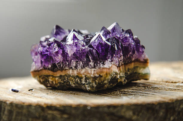 crudo amatista roca con reflejo en madera natural amatista de cristal - amethyst fotografías e imágenes de stock