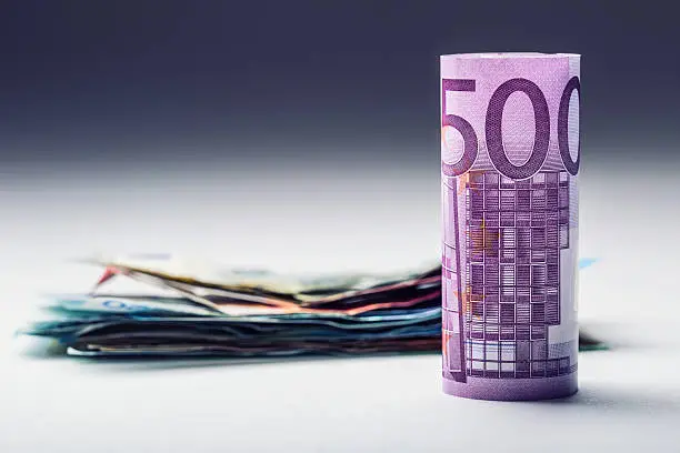 Several hundred euro banknotes stacked by value. Euro money concept. Rolls Euro  banknotes. Euro currency. Announced cancellation of five hundred euro banknotes. Banknotes stacked on each other in different positions. Toned photo.