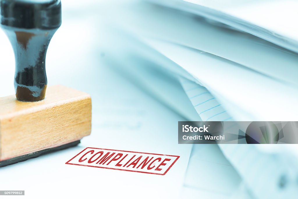 Compliance stamp on papers Compliance stamp on papers, shallow depth of field, focus on stamp Obedience Stock Photo