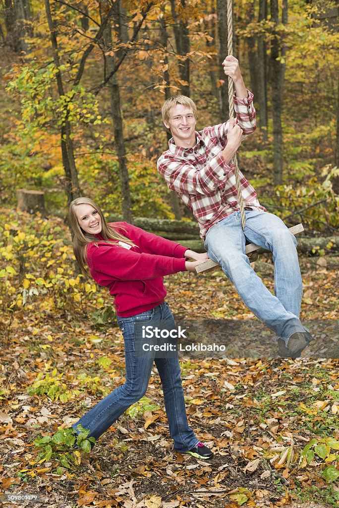 Teenager-Mädchen und Jungen spielen mit Seilschaukel - Lizenzfrei Herbst Stock-Foto