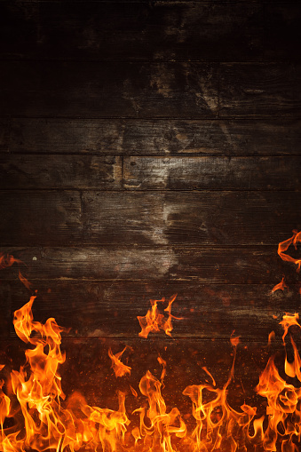 Fire flames and burnt wooden texture on background