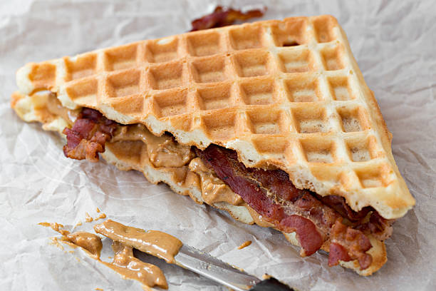 A high angle extreme close up shot of  PB and bacon waffle sandwich.