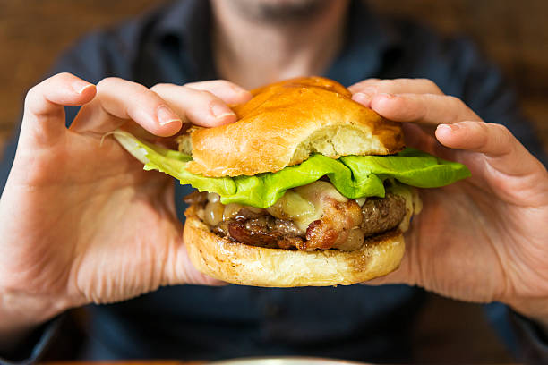 istock Juicy Bacon Cheese Burger in Hands About to Be Eaten 509803708