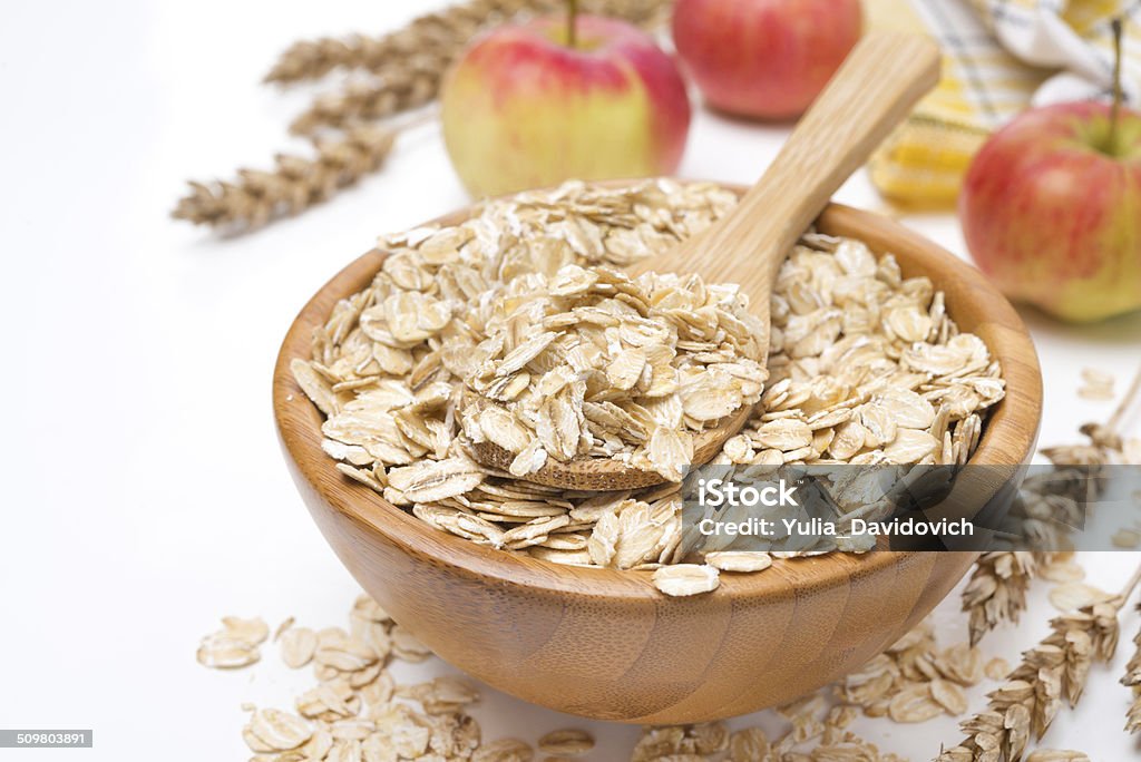 Copos de avena y manzana tazón de madera, aislado - Foto de stock de Agricultura libre de derechos