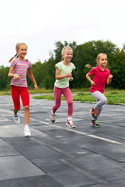 istock three  girls run down around the stadium 509803913