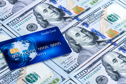 Blue worldwide credit card for online paying on american dollars background