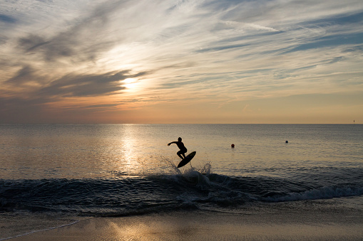 Surfer's Silhouette jumping at sunrise