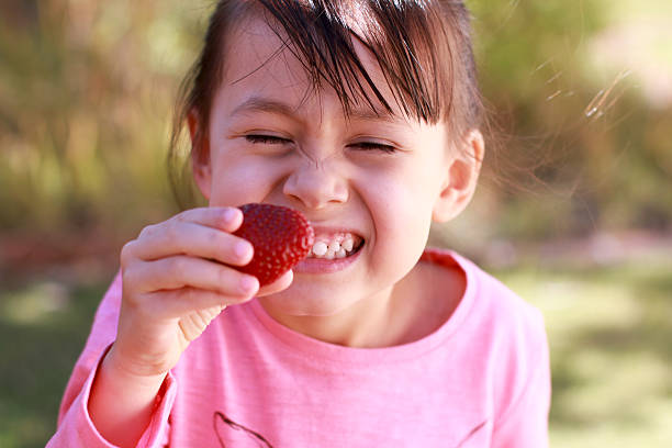 istock Little girl eating strawberry 509806755