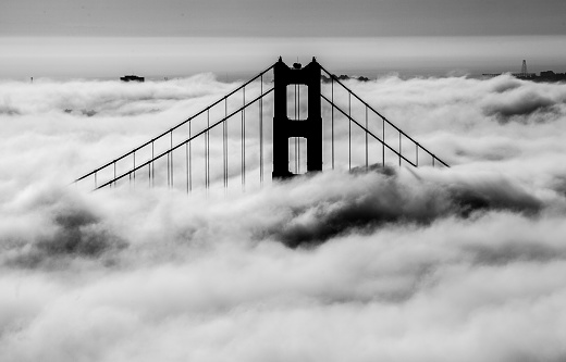 The south tower of the Golden Gate Bridge rises out of the fog on a summer day