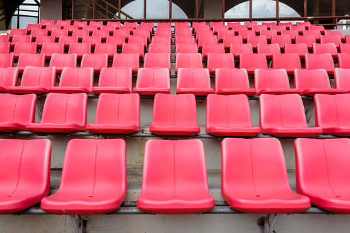 Empty red seats in football stadium.