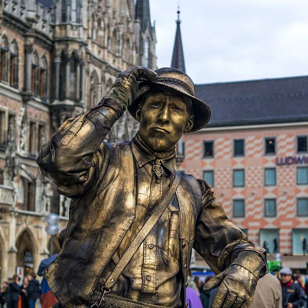 Munich, Germany - April 13, 2013: street pantomime at the marienplatz in Munich earns money as a typical bavarian rural old person. The actor welcomes the audience.
