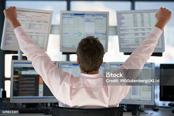 Stock Trader Watching Computer Screens With Hands Raised Stock Photo - Download Image Now