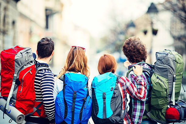 Back view of young backpackers in the city.