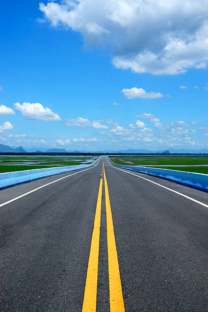 istock Empty road and the yellow traffic lines with blue sky. 509827973