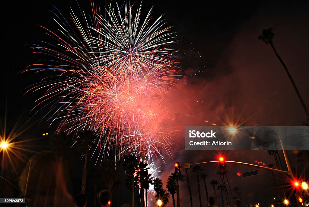 Fireworks Show With Palm Trees And People A fireworks show with people watching, and palm trees in the background, in Santa Barbara, California. 12 O'Clock Stock Photo