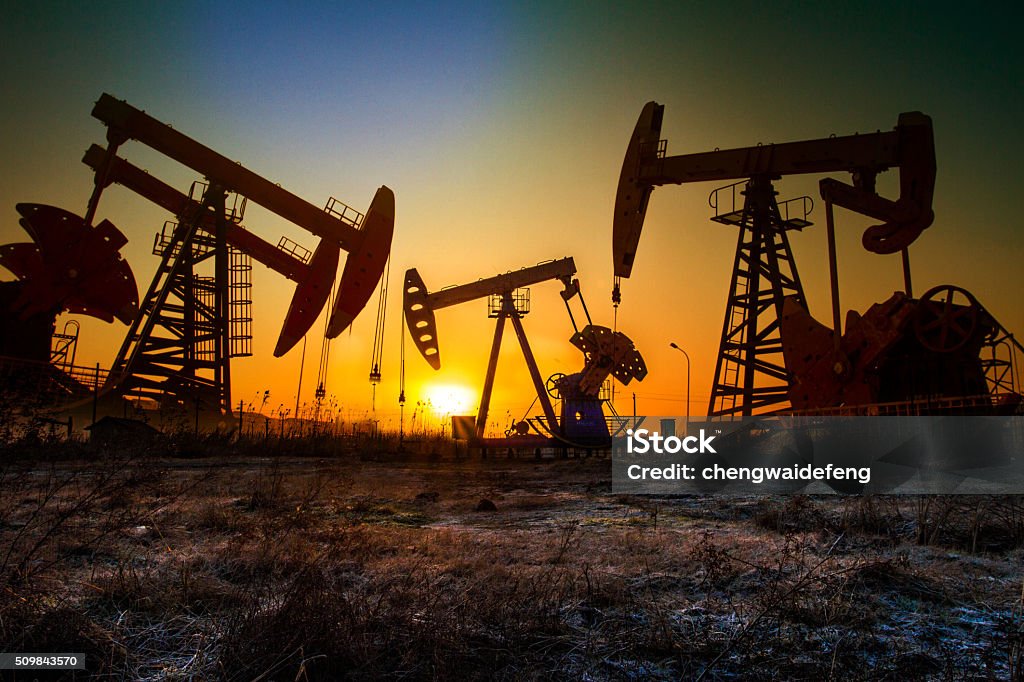 pumping unit in sun Crude Oil Stock Photo