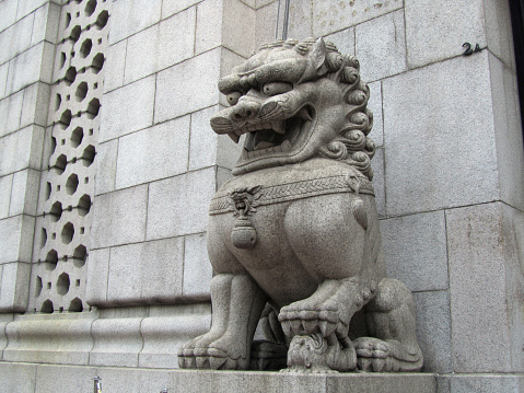 Chinese lion in front of a bank in Hong Kong, China.