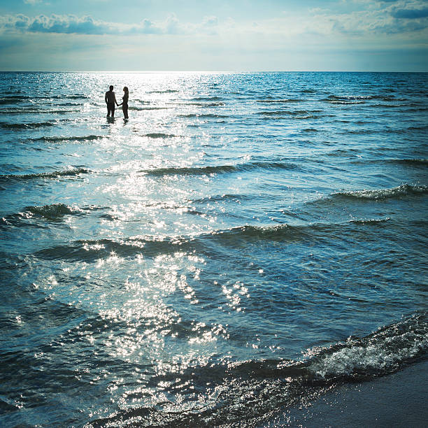istock Young Couple Silhouette In Seawater 509853796