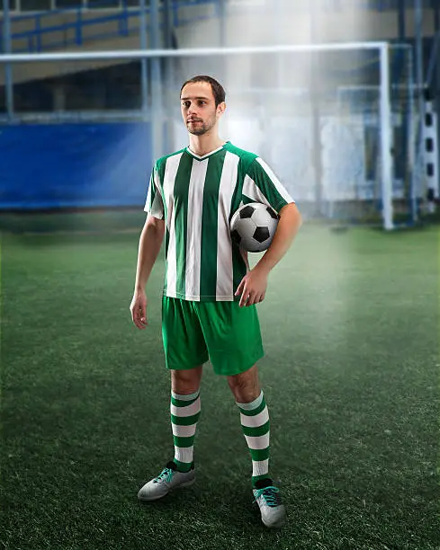 Football player holding a ball on the football ground