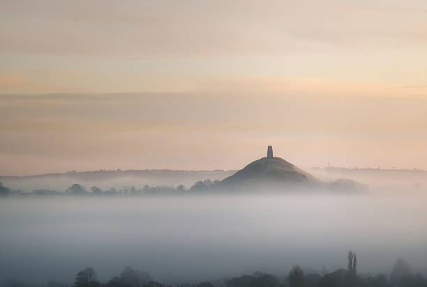 Land of Legends Misty winter scenery of iconic Somerset landmark - Glastonbury Tor anglo saxon photos stock pictures, royalty-free photos & images
