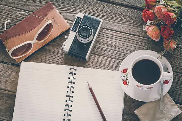 Photo of Vintage Film Look: cup of coffee with camera and notebook