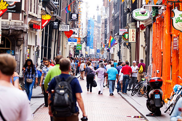Crowd of tourists in Warmoesstraat Amsterdam, The Netherlands - June 9, 2014: Capture f crowd of people and tourists walkign in street Warmoesstraat in Wallen in Amsterdam in summer. In are many bars and coffee shops and b&bs and hotels. wellen stock pictures, royalty-free photos & images