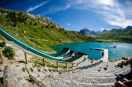 Tignes, France - July 30, 2012: Lake  of Tignes and a jump slide; beautiful nature up in the European Alps. 