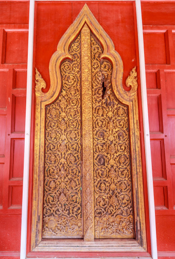 This antique door is located at a public temple, Wat Yai Suwannaram in Petchburi, Thailand. The damage on the upper right hand of the door was axed by Burmese soldier in an attempt to get to the people hiding inside.