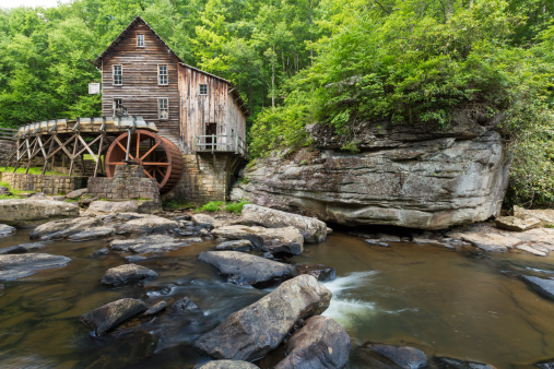 A grist mill along a creek in the woods.