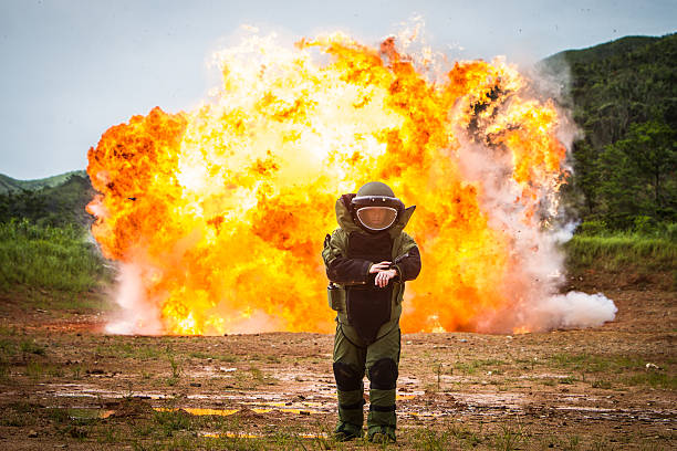 Bomb demolition A US EOD bomb specialist walks away as a huge fireball erupts behind him. explosive photos stock pictures, royalty-free photos & images