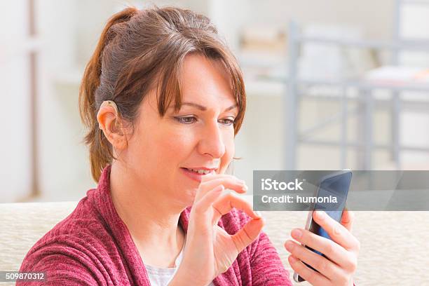 Deaf Woman Using Sign Language On The Smartphone Stock Photo - Download Image Now - Deafness, Sign Language, Hearing Aid