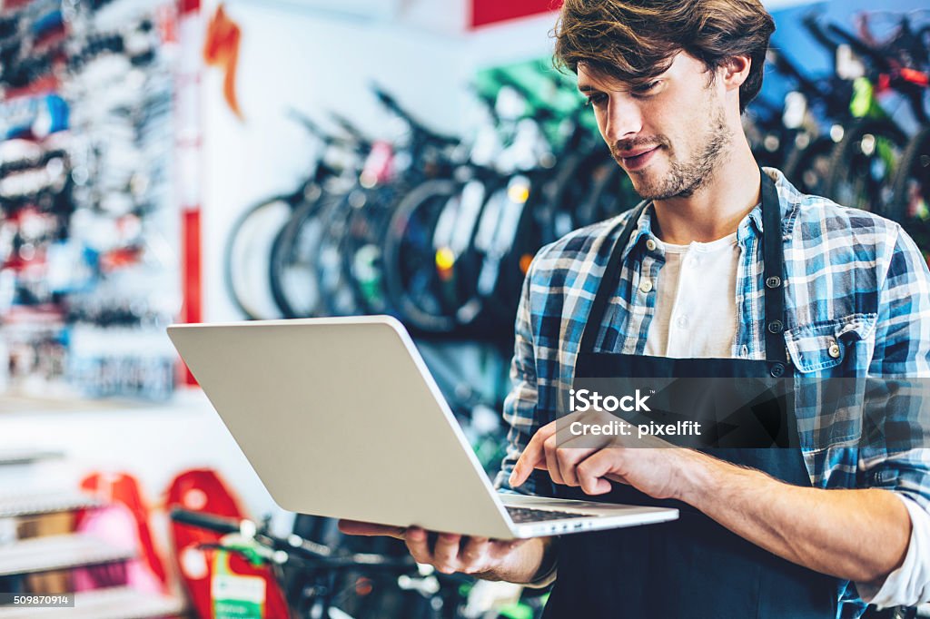 Fahrrad shop-Besitzer arbeiten mit Laptop - Lizenzfrei Fahrradgeschäft Stock-Foto Fahrrad shop-Besitzer arbeiten mit Laptop - Lizenzfrei Fahrradgeschäft Stock-Foto