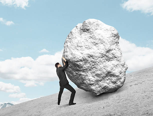 istock businessman pushing stone 509872398