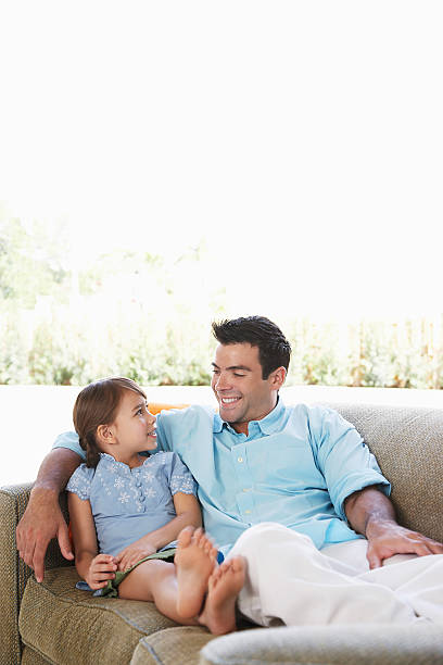 istock Father And Daughter Relaxing On Sofa 509892357