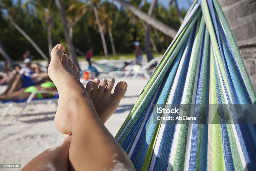 Beautiful female legs on the beach Vacation holidays. Woman feet closeup of girl relaxing on exotic beach, enjoying sun on sunny summer day. Tropical Resort. Adult Stock Photo