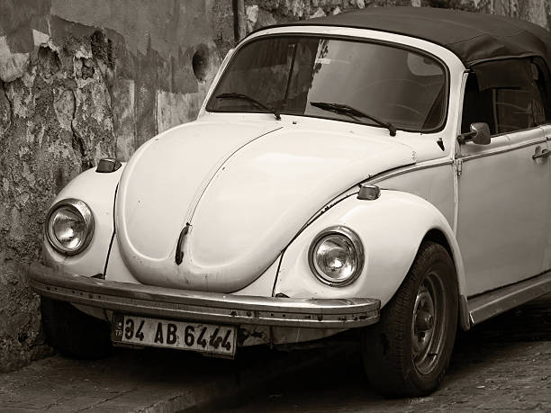 Istanbul, Turkey - August 30, 2013: An old yellow convertible VW Beetle was parked next to the stone wall.