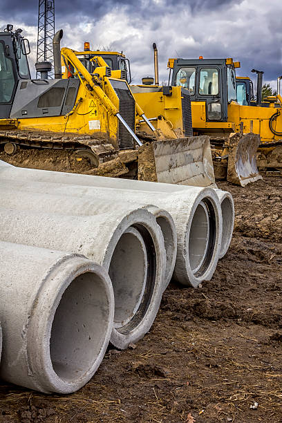 istock Concrete drainage pipes and bulldozers 509909980