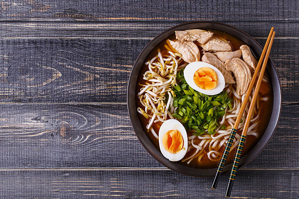Japanese ramen soup with chicken, egg, chives and sprout. Japanese ramen soup with chicken, egg, chives and sprout on dark wooden background. noodle soup photos stock pictures, royalty-free photos & images